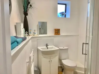a white bathroom with a toilet and a sink at Enchmarsh Farm Byre in Church Stretton