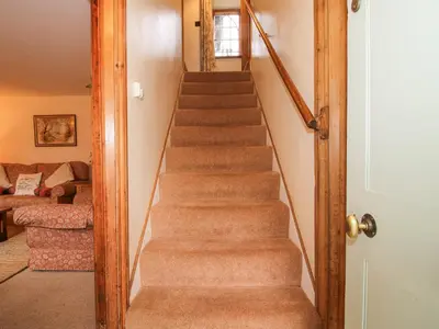 a staircase in a living room with a stair case at Rowan Cottage in Bishops Castle