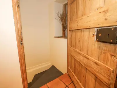 a wooden door in a room with a shelf at Rowan Cottage in Bishops Castle