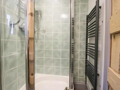a shower with a glass door in a bathroom at Rowan Cottage in Bishops Castle
