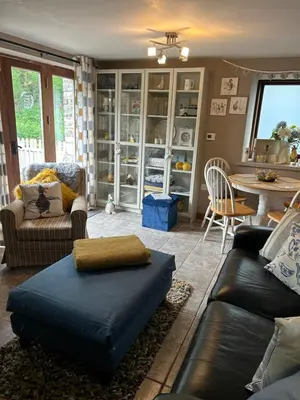 a living room with a couch and a table at Cosy riverside property in Aber-Brân