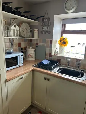 a kitchen with a sink and a microwave at Cosy riverside property in Aber-Brân