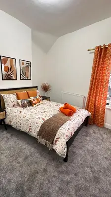 a bedroom with a bed with orange pillows on it at Bryn Aber-The House on the Hill in Llangollen