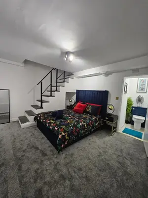 a bedroom with a bed and a staircase at Bryn Aber-The House on the Hill in Llangollen