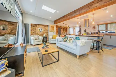 a living room with a couch and a table and a kitchen at Coogee View Lodge in New Quay