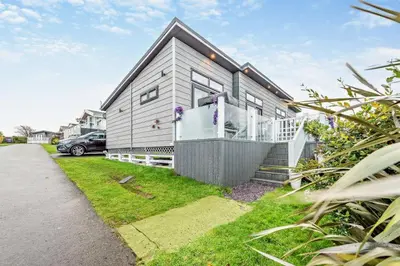 a house with a car parked in front of it at Coogee View Lodge in New Quay