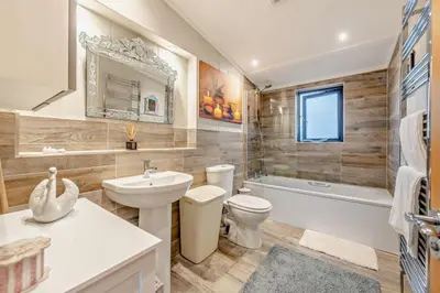 a bathroom with a sink and a toilet and a tub at Coogee View Lodge in New Quay