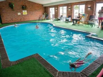 a large swimming pool with people swimming in it at Coogee View Lodge in New Quay