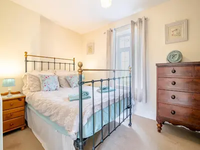 a bedroom with a bed and a dresser and a window at Court House in Hay-on-Wye