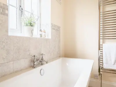 a white bath tub in a bathroom with a window at Court House in Hay-on-Wye