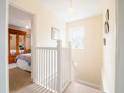 a white hallway with a crib in a bedroom at Court House in Hay-on-Wye