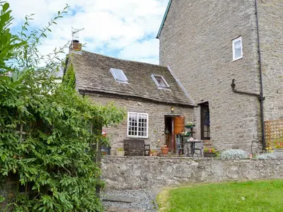 an old stone house with a stone wall at The Bothy-E2934 in Clun