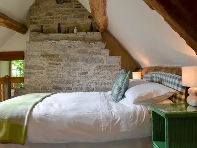 a bed in a room with a brick wall at The Bothy-E2934 in Clun