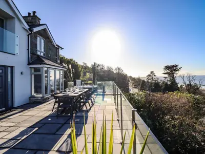 a patio with tables and chairs on a building at Aelfor in Harlech