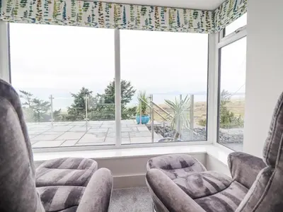 two chairs in a room with a large window at Aelfor in Harlech
