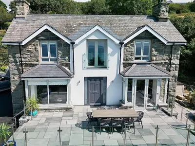 a white house with a picnic table in front of it at Aelfor in Harlech