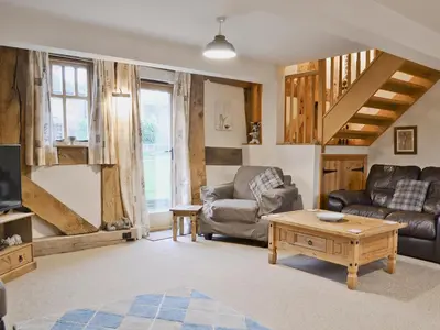 a living room with a couch and a table at The Olde Granary - E4298 in Halston