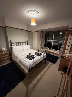 a bedroom with a bed and a large window at Glannant - 5 Bed & 4 Bathroom - Fairbourne, Barmouth, Mawddach Estuary in Arthog