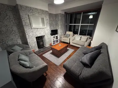 a living room with two couches and a fireplace at Glannant - 5 Bed & 4 Bathroom - Fairbourne, Barmouth, Mawddach Estuary in Arthog