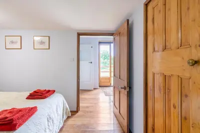 a bedroom with a bed and a wooden door at Ashford Bridge Barn in Ludlow