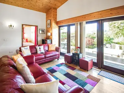 a living room with a red leather couch and sliding glass doors at Ash Lodge - Hw7442 in Nantmel