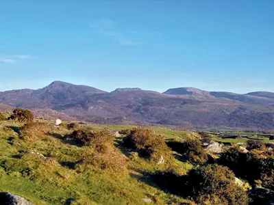 a view of a field with mountains in the background at Rhiwgoch - Hw7449 in Harlech