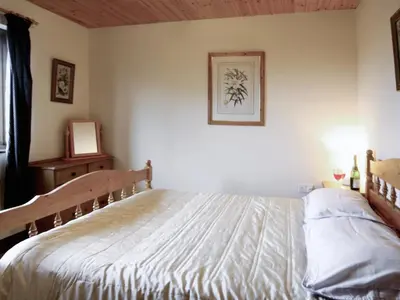 a bedroom with a bed and a picture on the wall at Woodside Lodge - Hw7520 in Penybont