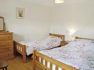 a bedroom with two beds and a dresser at Dol Afon - Hw7588 in Llanuwchllyn