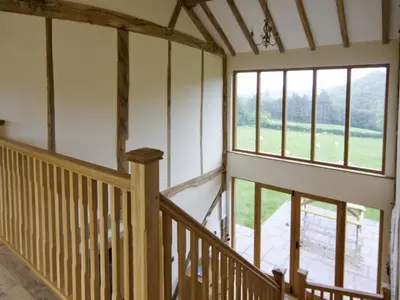 an empty room with a staircase and windows at Cwm Corn Barn - Hw7662 in Mochdre