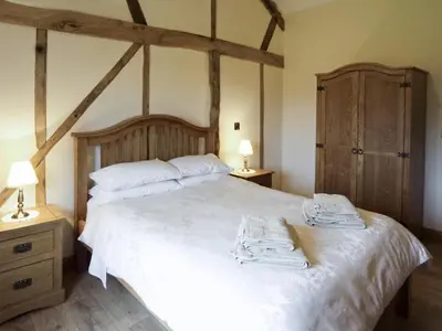 a bedroom with a bed with two towels on it at Cwm Corn Barn - Hw7662 in Mochdre