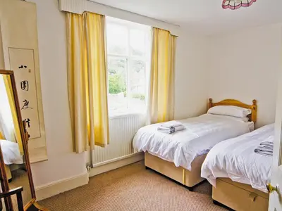 a bedroom with two beds and a window at Station House - Hw7742 in Glyn-Dyfrdwy