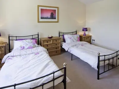 a bedroom with two beds and two night stands at Cefnaire Isaf in Newtown