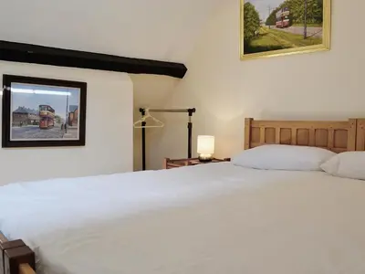 a bedroom with a white bed and a window at Porter's Lodge in Glyn-Dyfrdwy