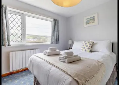 a bedroom with a large bed with towels on it at Aberceiro Bungalow in Aberystwyth