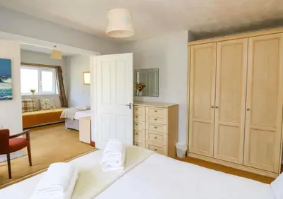 a bedroom with a bed and a room with a bed and a desk at Aberceiro Bungalow in Aberystwyth