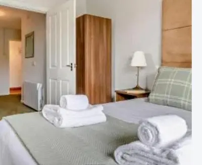 a bedroom with a bed with towels on it at Aberceiro Bungalow in Aberystwyth