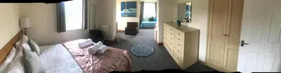 a bedroom with a bed and a dresser and a mirror at Aberceiro Bungalow in Aberystwyth