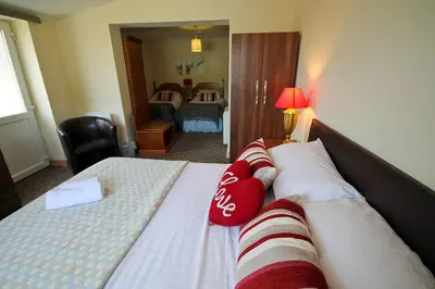 a hotel room with a bed with red and white pillows at Aberceiro Bungalow in Aberystwyth