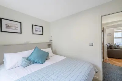 a bedroom with a bed with a blue pillow on it at Popular Sea View Apartment in Aberdyfi