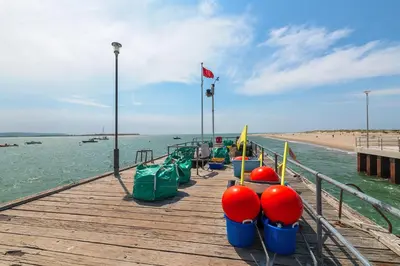 a pier with a row of boats on the beach at Popular Sea View Apartment in Aberdyfi