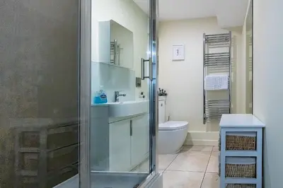 a bathroom with a shower and a sink and a toilet at Popular Sea View Apartment in Aberdyfi
