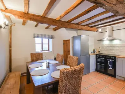 a kitchen with a table with chairs and a refrigerator at Uk46590 - Longmynd in Church Stretton