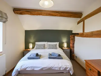 a bedroom with a large bed with two blue towels at Uk46590 - Longmynd in Church Stretton