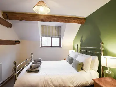 a bedroom with a white bed with a green wall at Uk46590 - Longmynd in Church Stretton