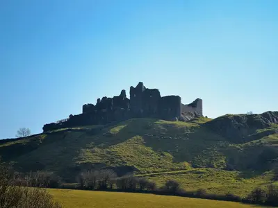 a castle on top of a green hill at West Barn in Llansadwrn