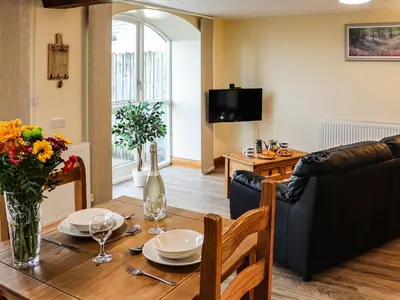 a living room with a wooden table and a dining room at Hirnant - Uk48512 in Bala