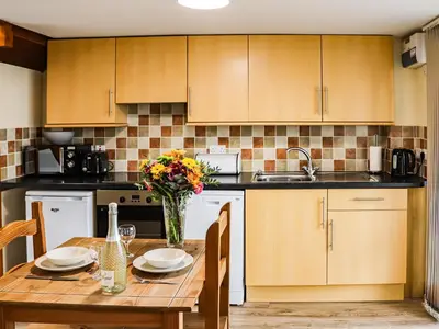 a kitchen with a table with a vase of flowers at Hirnant - Uk48512 in Bala