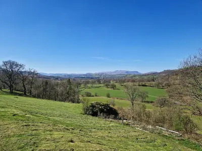 a green field with trees and hills in the background at Berwyn - Uk48507 in Bala