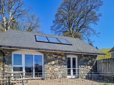 a stone house with two windows and a table at Berwyn - Uk48507 in Bala