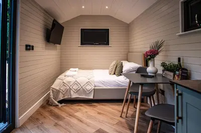 a small bedroom with a bed and a table at Dinas Lodge with private hot tub in Llangollen